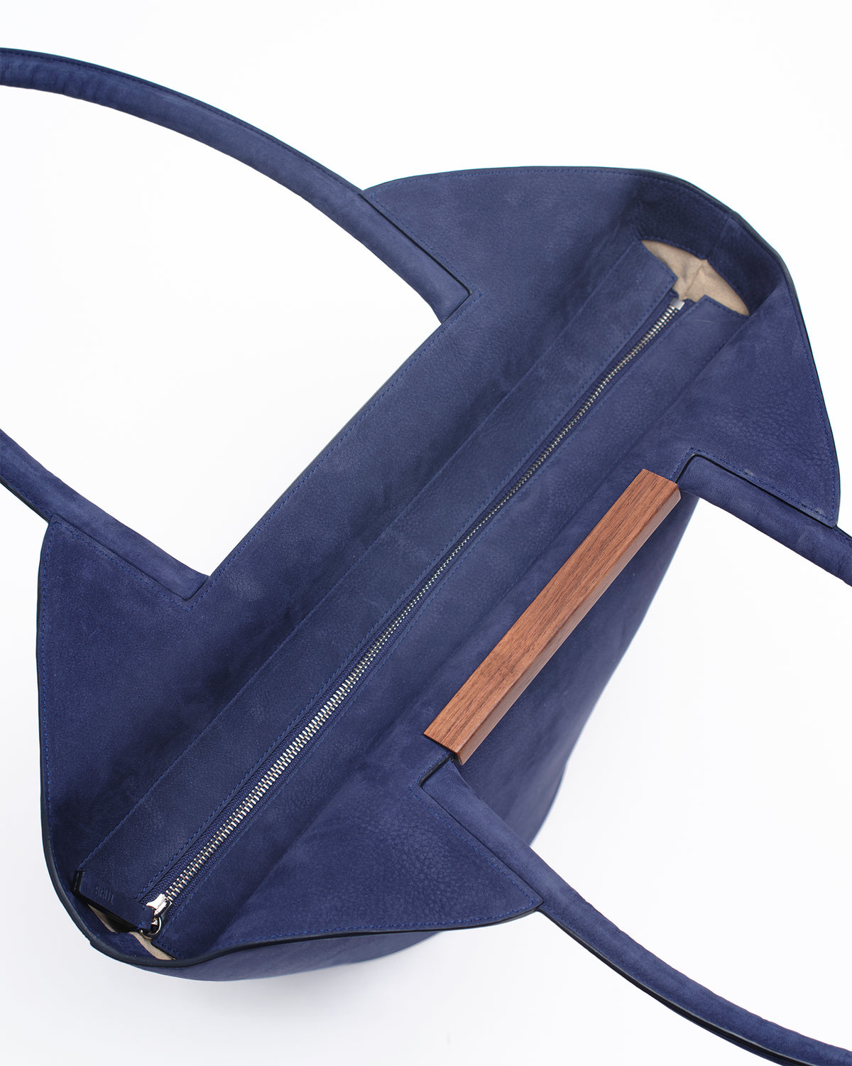 Garden tote bag in dark blue featuring grained taurillon leather and walnut wood bar detail.